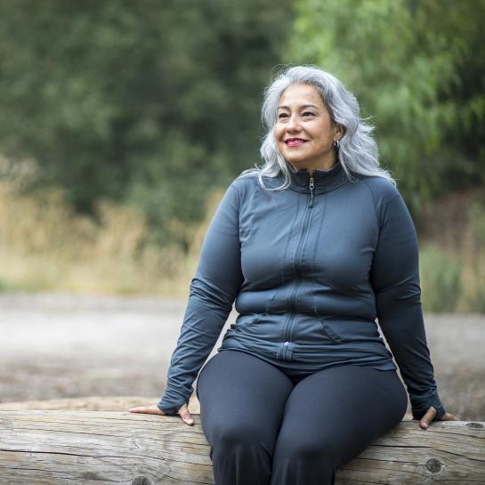 Woman enjoying the outdoors sitting on log