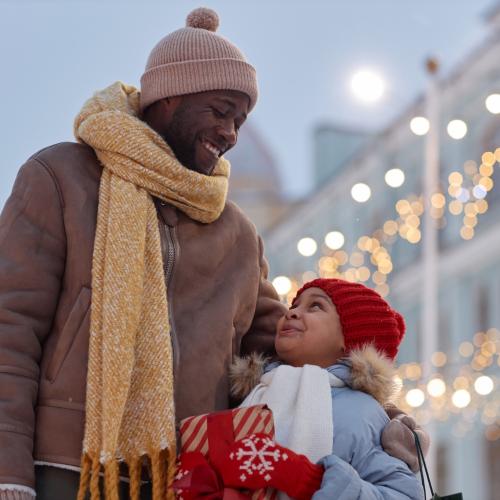 Happy African American father and daughter outside taking gifts to family