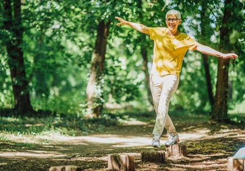 Senior woman walking on wooden posts