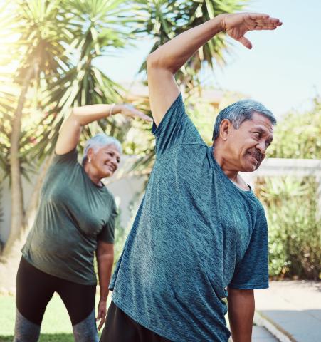 Senior Hispanic couple doing stretches outdoors