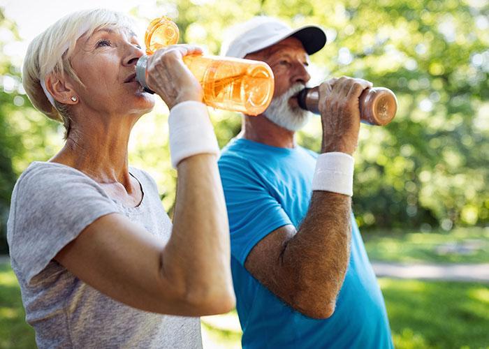 senior couple water bottles sunny day